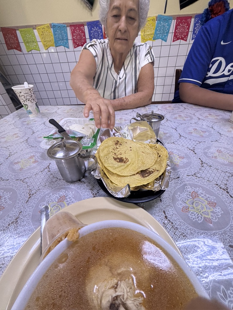Grandmother reaching for tortillas